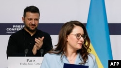 Președintele Ucrainei, Volodimir Zelenski, o aplaudă pe Iulia Svîrîdenko, prim-vicepremier și ministru al Economiei, după semnarea documentelor cu ministrul francez de externe la Palatul Elysee din Paris, pe 7 iunie 2024.