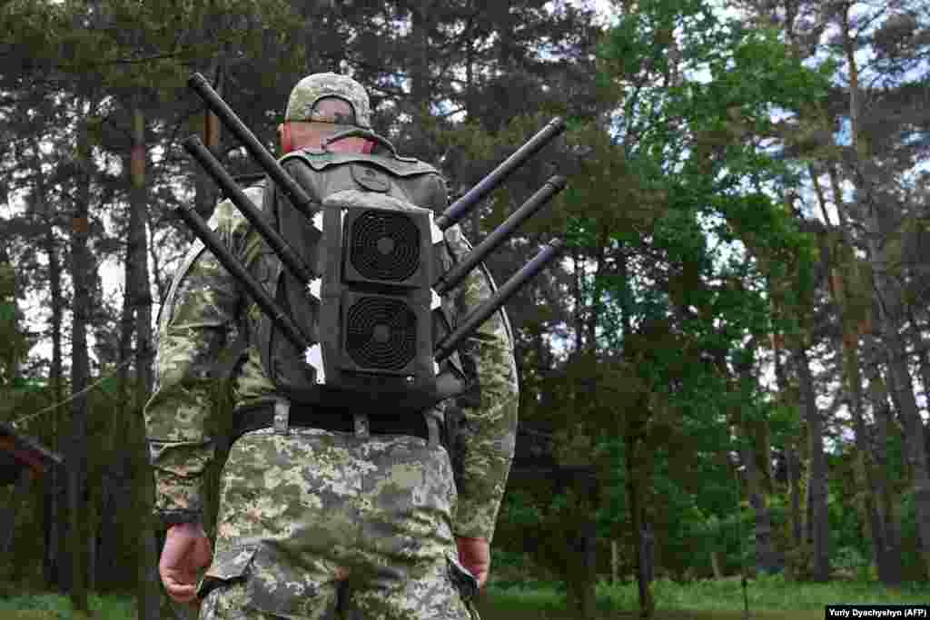 Український військовий з «антидроновим наплічником» на демонстрації засобів глушіння, що відбулася на Львівщині у травні    