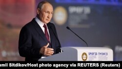 Russian President Vladimir Putin delivers a speech during a session of the St. Petersburg International Economic Forum in St. Petersburg on June 16.