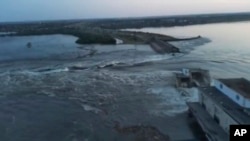 Кадр із відео наслідків руйнування дамби Каховської ГЕС, опублікованого 6 червня 2023 року президентом Зеленським. Влада Уrраїни звинуватила російську армію у підриві машинного залу гідроелектростанції зсередини. Натомість окупаційна адміністрація звинувачує ЗСУ