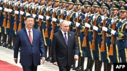 Președintele rus Vladimir Putin trece pe lângă o gardă de onoare cu omologul său chinez, Xi Jinping, la Beijing, în 2024(fotografie de arhivă).