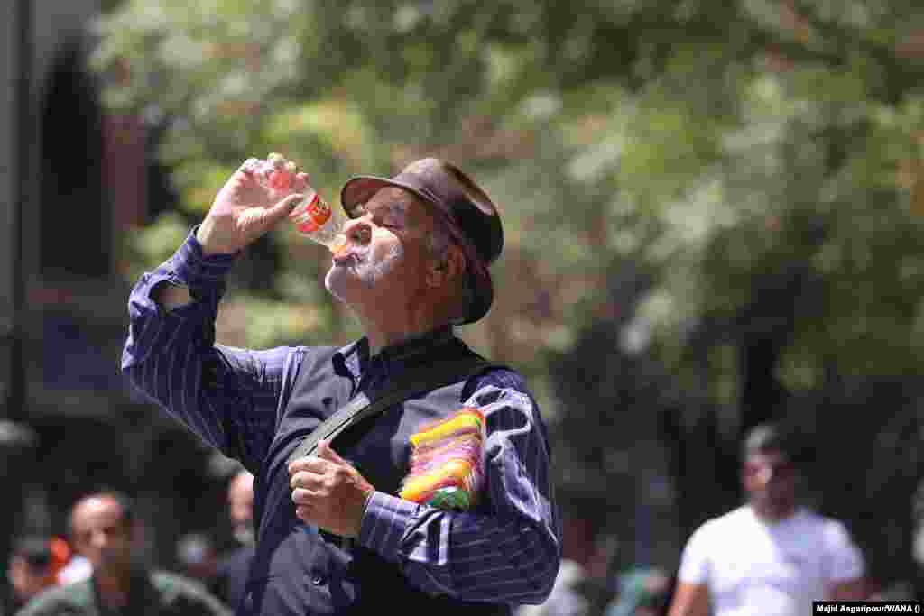 A man drinks during the heat wave in Tehran. The nationwide shutdown of offices, banks, and schools is aimed at conserving energy as the country's poorly maintained power grid struggles with the higher-than-usual demand.
