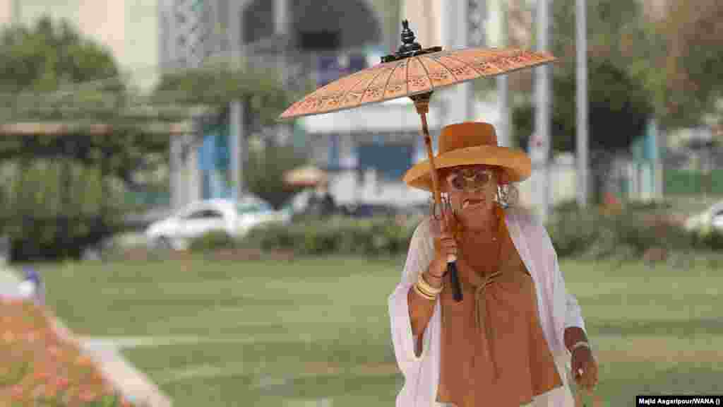 A woman carries a parasol as she tries to stay cool amid an "unprecedented" heat wave in Tehran on August 2. The capital hit 37 degrees Celsius, while other parts of the country saw temperatures hit 40 degrees. The extreme heat comes as rising anger over a range of economic issues as well as water outages has led to protests against the government's mismanagement of resources.  