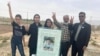 Abolfazl Adinezadeh's family hold a picture of the young man, who was killed during protests in Iran in October 2022. (file photo)