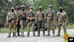 In a photo released by Belarus's Defense Ministry on July 20, Belarusian special forces and mercenaries pose during maneuvers near the border city of Brest.