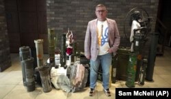 Євген Рищук, мер міста Олешки Херсонської області, біля речей, що пов’язані з війною, які зібрані для продажу на аукціоні з метою фінансування допомоги. Київ, 8 червня 2023 року