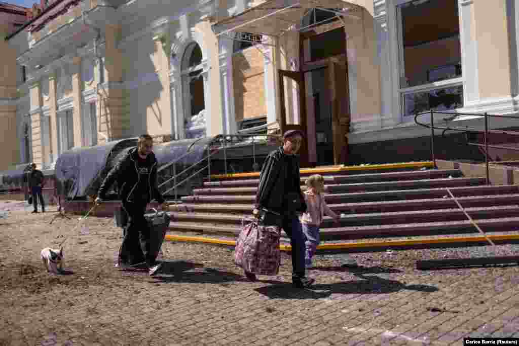 People run for cover near the train station in Kherson during an early morning Russian strike on May 3. Local officials said one person was killed at the train station and several others were seriously injured during the morning attack.