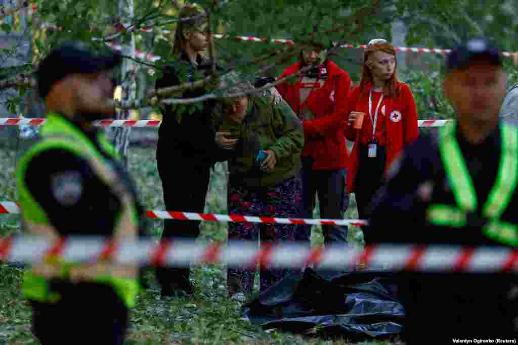 The woman is comforted by emergency responders at the scene. Lyudmyla, a local resident who declined to provide her surname said, “Everything happened very fast, within probably 15 minutes: the air-raid siren, then the air-defense forces fired, then a cloud of brown smoke."