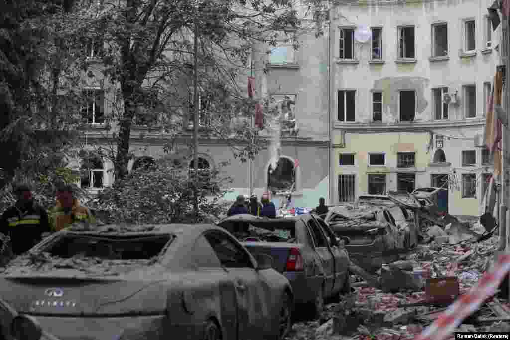 Rescue workers at the scene of a rubble-covered street. Lviv Mayor Andriy Sadovyi said around 60 apartments and 50 cars were damaged. 