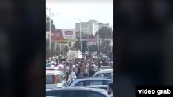 Таҷаммӯи кормандони Маркази савдои "Лола" дар шаҳри Кӯлоб. Акс аз навори видеоии корбари Радиои Озодӣ 26 май гирифта шудааст