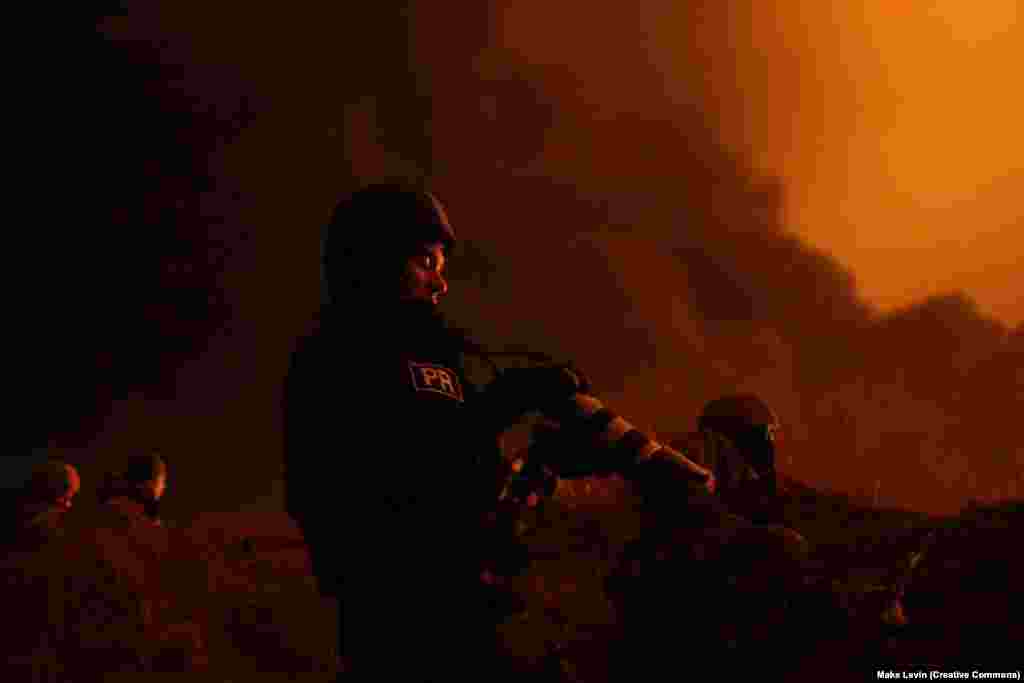 Marian Kușnir, jurnalist vizual RFE/RL, filmează lângă Kiev în prima săptămână a invaziei la scară largă a Rusiei în Ucraina în 2022.Pe fondul războiului Rusiei împotriva Ucrainei, RFE/RL a realizat reportaje intensive pe teren despre invazie. Astăzi, RFE/RL este o importantă organizație media internațională, care realizează reportaje în țări în care „o presă liberă este fie interzisă de guvernele autoritare, fie nu este pe deplin instituită”.