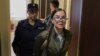 Escorted by a policewoman, Viktoria Petrova attends one of her trial hearings. By posting anti-war messages on social media, she has been accused of spreading "false" information about the Russian Army.