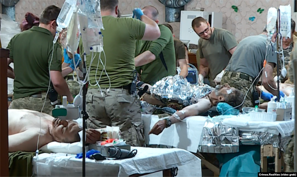 Гаряча робота... Операційна стабілізаційного пункту. Кінець липня 2023 року. Південний напрямок фронту на початку контрнаступу ЗСУ.  Один із медиків сказав кореспондентам Крим Реалії: «Ми не знаємо, скільки сіл взяли, але бачимо, якою ціною»