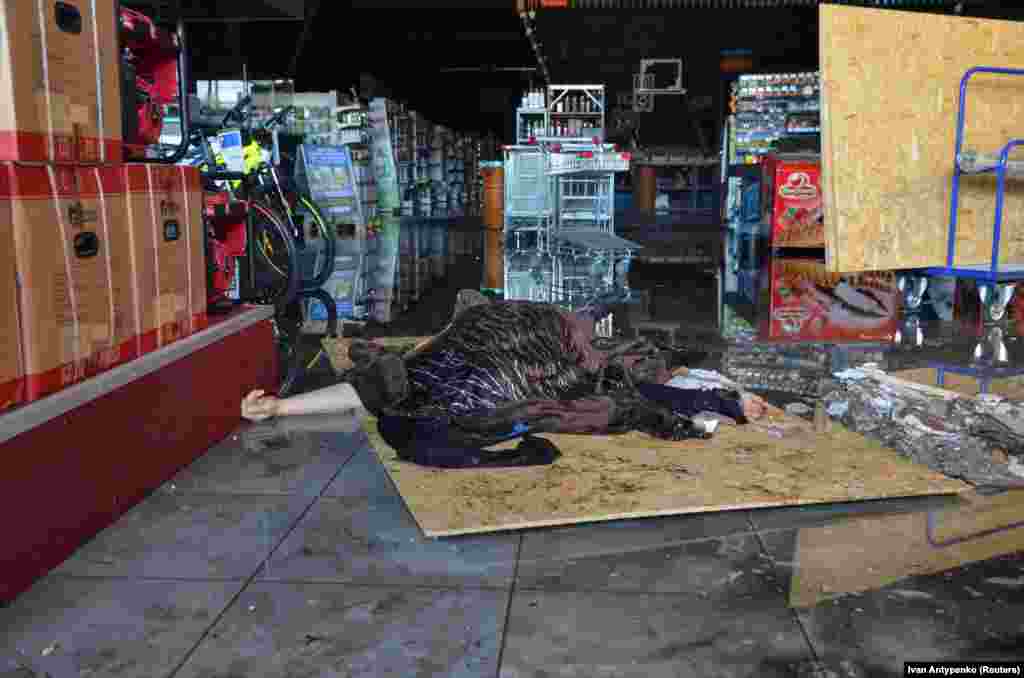 A blanket covers the body of a person killed during the attack inside a shopping center in Kherson. 