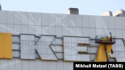 Рабочие снимают вывеску IKEA с одного из российских моллов