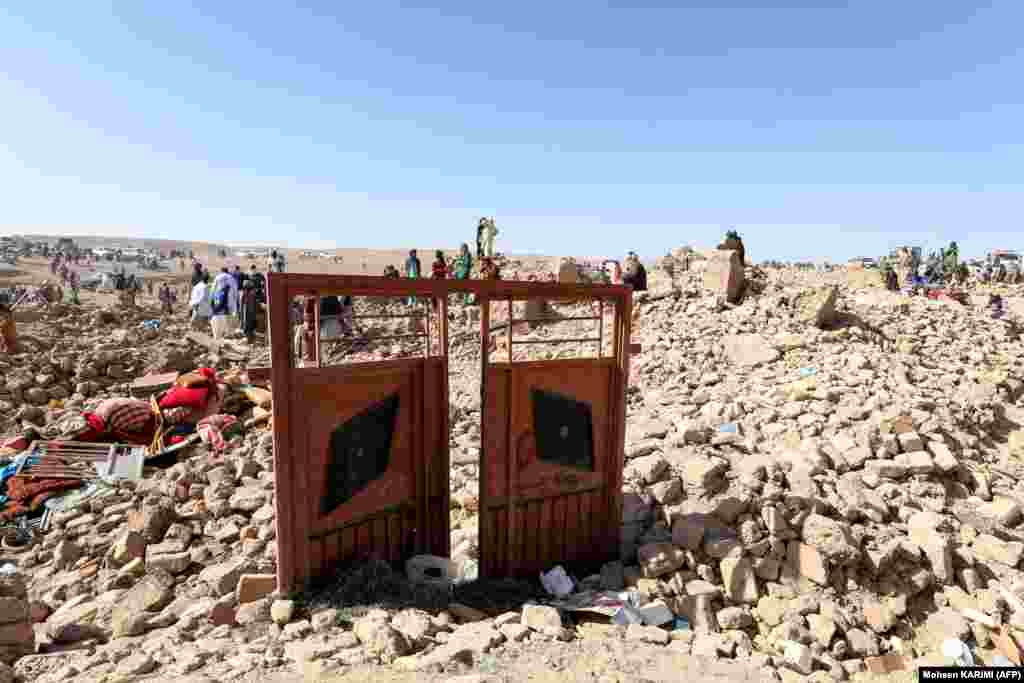 Afghan residents clear debris as they continue their search for bodies in the rubble of homes destroyed during the earthquakes.  