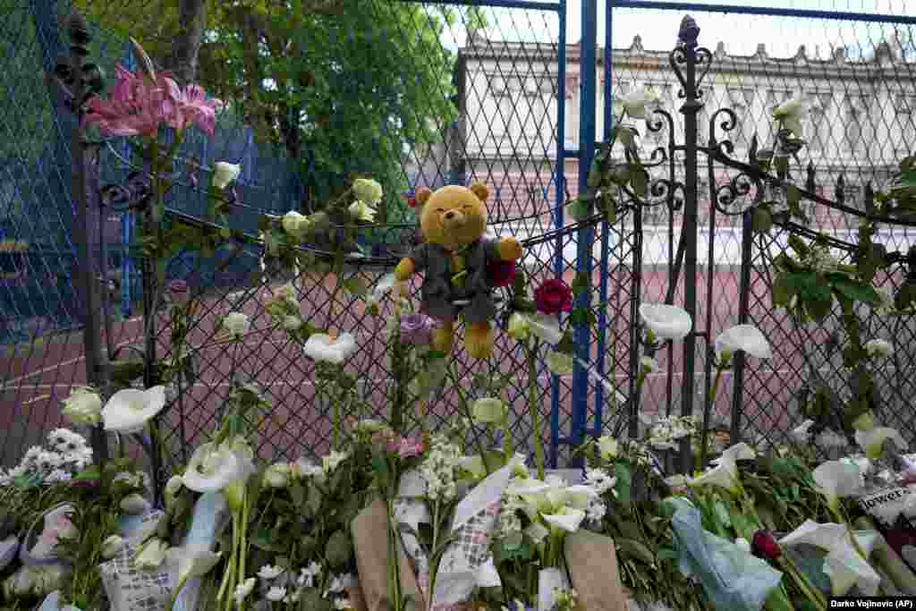 Цветы и игрушки возлагают жертвам возле школы Владислава Рыбникара в Белграде, Сербия, 4 мая 2023 года. 13-летний подросток открыл стрельбу в своей школе в столице Сербии. До прихода полиции он успел убить нескольких учеников и охранника. Несколько детей и учитель также были госпитализированы. (AP Photo/Darko Vojinovic)