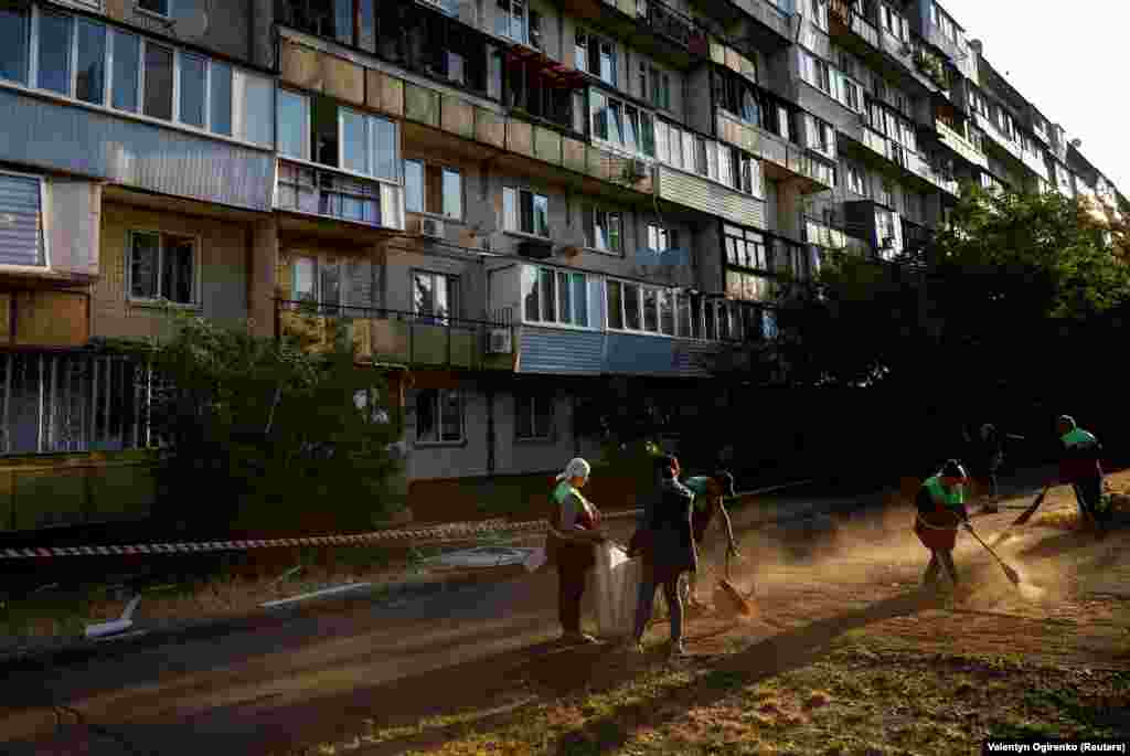 Municipal workers clear away the debris at the site of the residential building damaged during the early morning attack. Russia has intensified missile and drone attacks on the Ukrainian capital as Kyiv prepares to launch a counteroffensive. Russia says Ukrainian shelling of border areas has increased in recent weeks as Kyiv prepares its counterattack