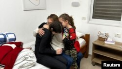 Исроил, пойгоҳи низомии Ҳатсерим, 26-уми ноябр. Моайян Зин духтаронаш Элаи 8 ва Дафна Элякими 14-соларо баъди раҳоиашон аз асорати гурӯҳи фаластинии Ҳамос ба оғӯш мекашад.