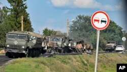 Russian military trucks damaged by Ukrainian shelling line a road in the Kursk region on August 9.