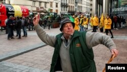 Учасник протесту фермерів кидається яйцями в поліцейських під час протесту у Брюсселі. Фермери своїми тракторами хотіли заблокувати Європейський парламент, протестуючи проти цінового тиску, податків і екологічного регулювання ЄС. Бельгія, 1 лютого 2024 року