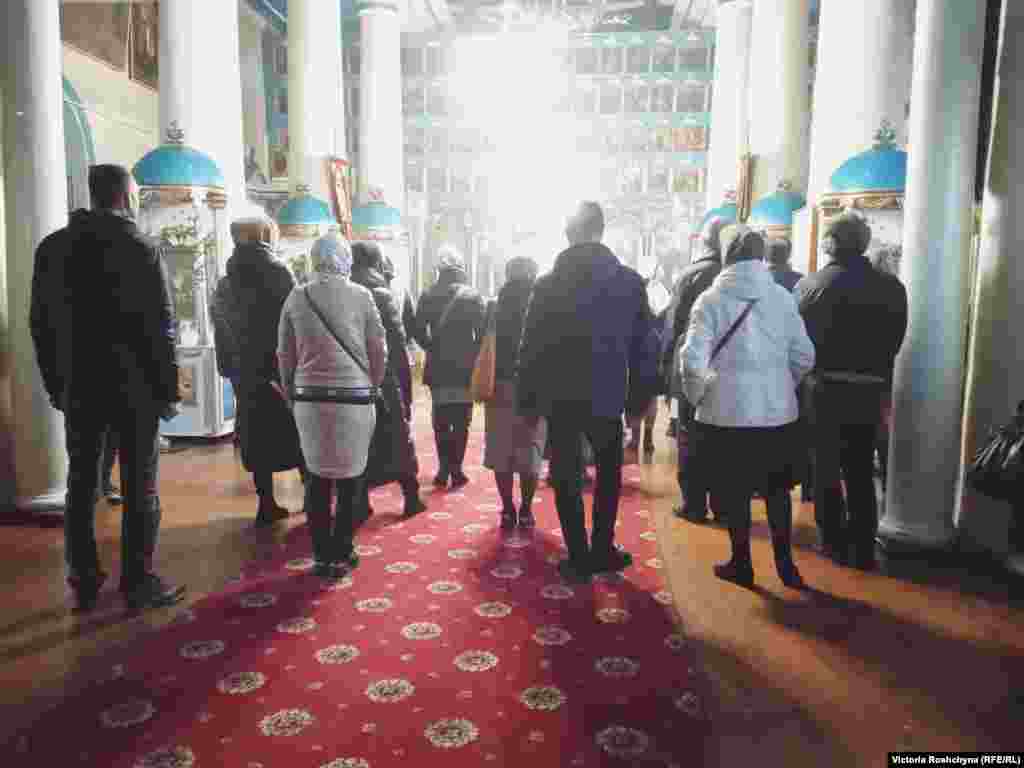 Ljudi na misi u okupiranom Hersonu. &quot;Mi se molimo. Radimo svoj posao. Naravno, želimo da i ovdje bude Ukrajina&quot;, rekao je sveštenik. &quot;Imam i porodicu. I oni plaču. Ali, trudim se da izbjegavam [pričati] o politici.&quot;