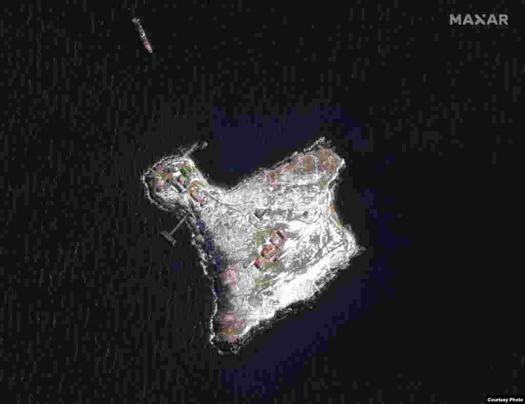 Супутниковий знімок острова Зміїний 13 березня 2022 року. Біля острова на якорі стоїть російський військовий корабель класу «Ропуха». Будівлі української прикордонної застави на острові ушкоджені.  Після початку 24 лютого широкомасштабного вторгнення Росії в Україну, капітан російського військового корабля запропонував українським прикордонникам острова Зміїний здатися, а інакше погрожував обстрілом. Українські прикордонники відповіли: «Російський військовий корабель, іди на ***». Ця фраза стала одним із девізів боротьби народу України із російськими загарбниками. 