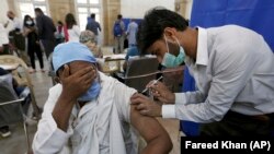 په کراچۍ کې روغتیاپال یو سړي ته د سینوفارم واکسین ستن لګوي - د ۲۰۲۱ز د مارچ ۱۰مې انځور