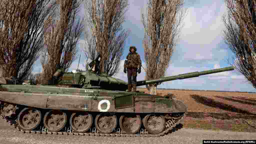 Український військовий стоїть на захопленому російському танку Т-72, який захопили українські військові в боях при звільнені села Лук‘янівка 