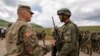 KOSOVO -- A U,S, soldier (L) chats with a soldier of the Kosovo Security Force (KSF), following the 'Defender Europe 21' military exercise in the village of Deve, May 28, 2021