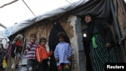 Iraqis stand outside a shelter at Umm al-Banin camp, one of the UNHCR's 94 camps for internally displaced persons in Baghdad.