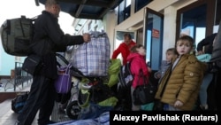 Гражданские лица, эвакуированные из оккупированной Россией Херсонской области Украины, прибывают на железнодорожную станцию в городе Джанкой, Крым, 20 октября 2022 года