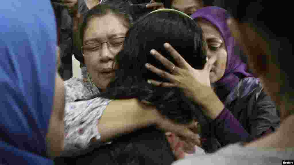 Relatives of a passenger of the missing Sukhoi aircraft grieve as the ill-fated plane's passenger list is checked at Halim Perdana Kusuma Airport in Jakarta.