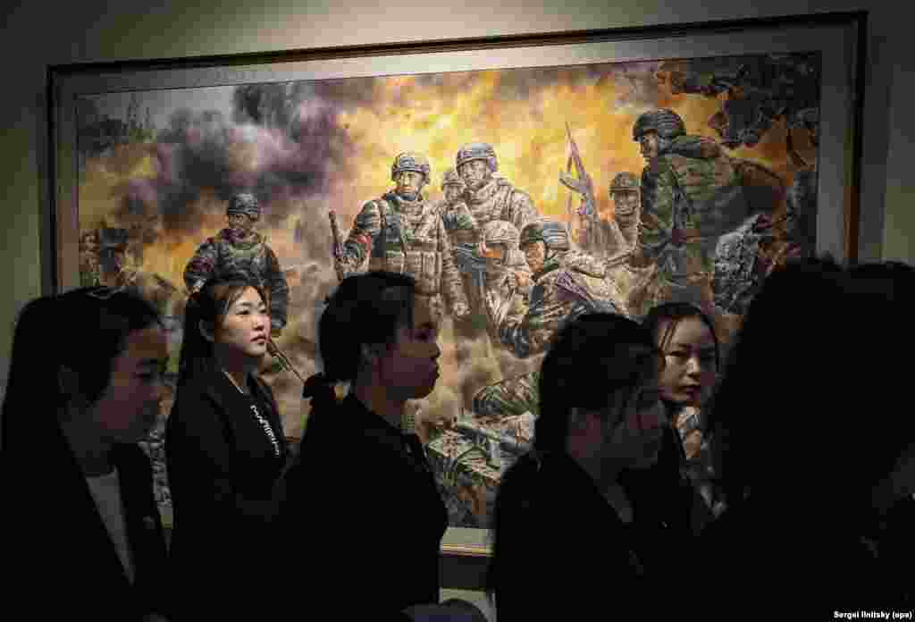 Группа северокорейских туристов перед картиной "Героические борцы за честь и достоинство Родины".