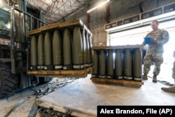 Американський військовослужбовець перевіряє піддони з 155-мм снарядами, які мають надійти в Україну, 29 квітня 2022 року на базі Повітряних сил у Довері, Делавер, США