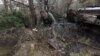A military sapper picks up unexploded parts of a cluster bomb in the Kyiv region, Ukraine, on April 10, 2022.