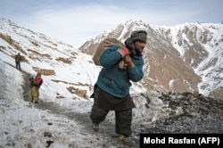 Miners carry sacks of stones to sort through for emeralds in the Mikeni Valley.