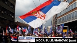 Protesters wave a large Serbian flag during a demonstration against NATO in Belgrade in March 2016.
