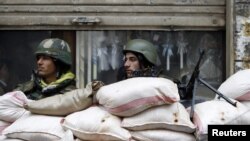 Syrian soldiers man a checkpoint in the city of Homs