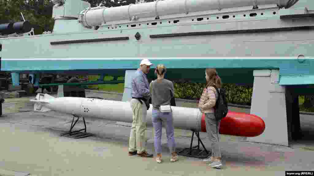 Відвідувачі розглядають військову техніку і озброєння – бронекатер і торпеду