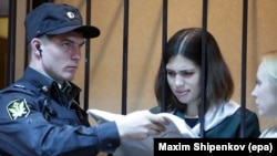 Feminist punk-rock band Pussy Riot member Nadezhda Tolokonnikova (right) reads a document during a court session in court in the town of Zubova Polyana, southeast from Moscow, in April.