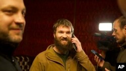 В центрі фото звільнений з російського полону заступник командира полку «Азов» Святослав Паламар розмовляє по телефону із рідними. Анкара, Туреччина. 21 вересня 2022 року