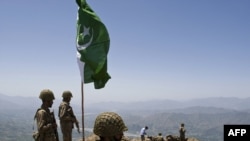 Pakistani soldiers stand guard atop a mountain overlooking the Swat Valley on May 22.