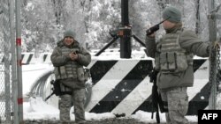 U.S. troops guard the main access checkpoint to the Manas air base.