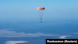 The space capsule carrying International Space Station crew members descends before landing in a remote area in Kazakhstan.