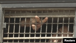 A Palestinian detainee gestures from the window of a bus as it leaves a jail ahead of a prisoner swap on October 18.