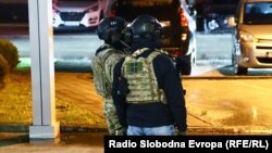 Neidentifikovana osoba u civilu, nosi pancirni prsluk sa crno-zlatnim štitom Vojske Srbije.