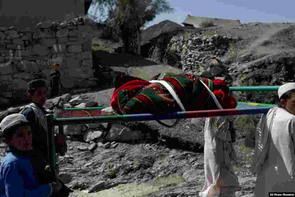Afghan boys carry the body of a child who was killed in the Golam Kot district in Paktika Province. 