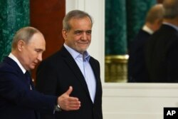 Президент Росії Володимир Путін (ліворуч) поруч із президентом Ірану Масудом Пезешкіаном під час церемонії в Кремлі в Москві, Росія, 17 січня 2025 року