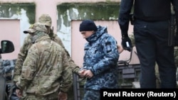 Затриманий український військовослужбовець виходить з вікна мікроавтобуса біля будівлі суду в окупованому Сімферополі, 28 листопада 2018 року